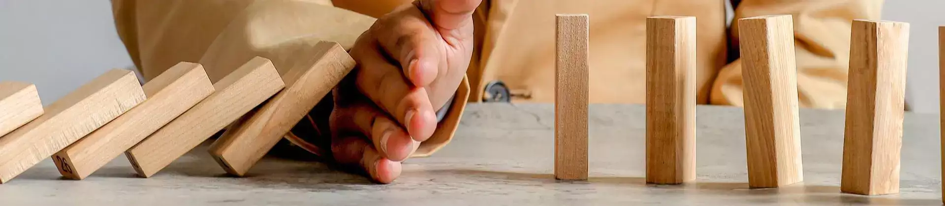 hand die vallende domino stenen stopt