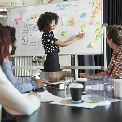 Vrouw presenteert mogelijke opleidingen die haar collega's kunnen volgen